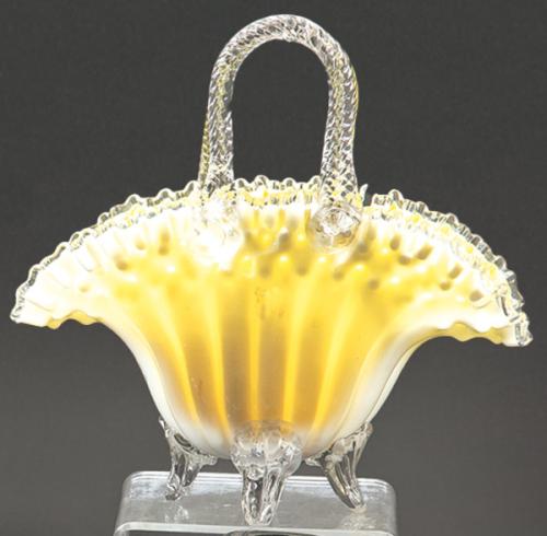 Cesta de cristal de Murano con boca rizada en blanco y amarillo con asas y patas en cristal transparente.