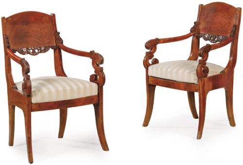 Pareja de butacas Imperio en madera de caoba y palma de caoba. Con respaldo ligeramente curvo y brazos terminados en volutas talladas con hojas de acanto. Finlandia, primer tercio S. XIX
