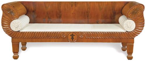 Canapé biedermeier en madera de nogal, con el frente y las patas talladas, y marquetería de motivos geométricos en maderas finas.