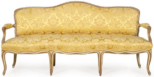 Canapé Luis XV en madera tallada, pintada y parcialmente dorada. Con tapicería adamascada dorada.