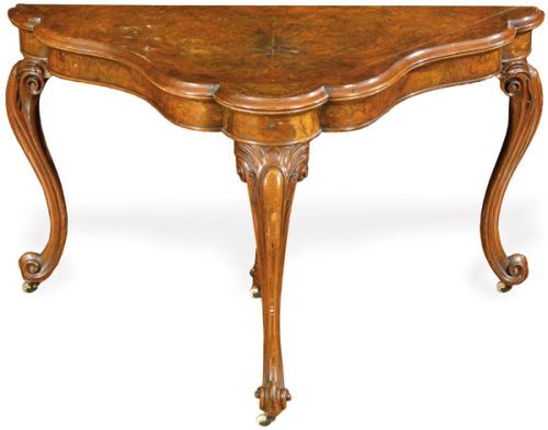 Mesa de juego William IV en madera de nogal, con tapa abatible con forma polilobulada, sobre patas cabriolé talladas.