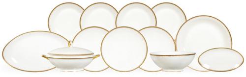 Vajilla art decón en porcelana fina, blanca, decorada con fileteado dorado en el borde, con un patrón clásico de motivos geométricos o estilizados en oro.