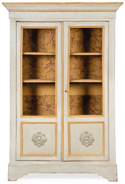 Armario convertido en vitrina, con dos puertas abatibles acristaladas y molduradas con decoración tallada en la parte inferior. En madera pintada de gris y ocre. Interior forrado con papel marmoreado. S. XIX