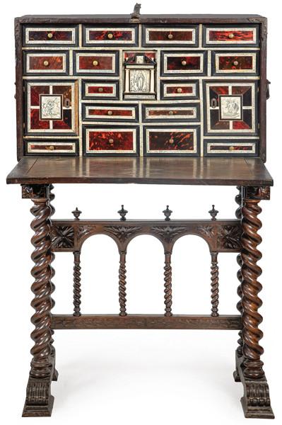 Papelera con tapa en madera de nogal, que al abrirse, revela un interior con gavetas de diferentes tamaños articuladas a partir de una pequeña portada de diseño clásico con placas de carey y hueso pirograbado.