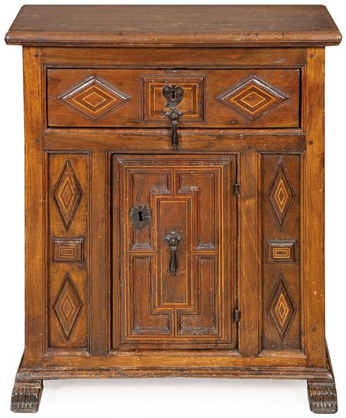 Taquillón en madera de nogal, con tapa rectanguar, sobre un cajón largo, debajo, una puerta central con decoración moldurada de tipo arquitectónico, descansa sobre peinazos terminados en ménsulas estriadas.España, principios S. XVII