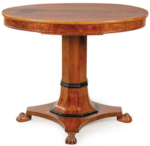 Mesa de centro Jorge III con tapa ovalada y un cajón en el frente, sobre pedestal de perfil hexagonal, sobre plataforma con lados cóncavos apoyada en patas en forma de garra de animal. Inglaterra, principios S. XIX