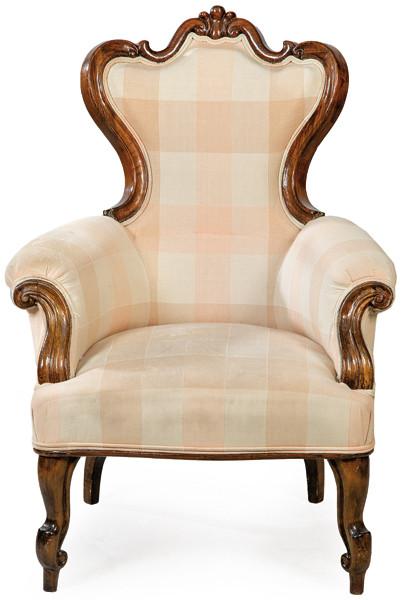 Butaca victoriana en madera de caoba tallada, con tapicería de tela, con cuadros de época posterior. Inglaterra, segunda mitad S. XIX