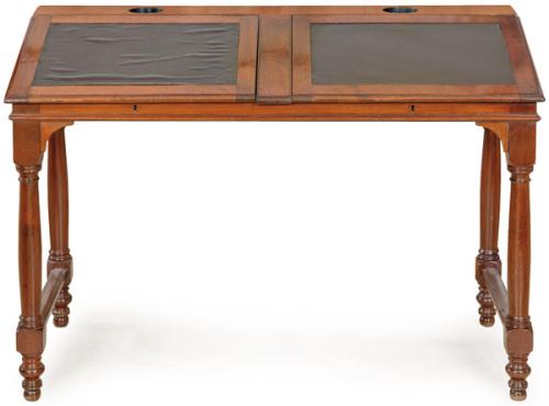 Mesa escritorio victoriana en madera de caoba, con dos supeficies para escribir inclinada y abatibles, recubiertas de cuero marrón; sobre patas torneadas. Inglaterra, segunda mitad S. XIX
