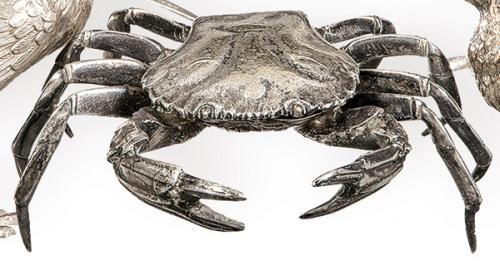 Caja en forma de cangrejo de metal plateado.