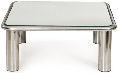  Mesa baja de estructura tubular realizada en acero cromado pulido, patas cilíndricas integradas en las esquinas mediante soldaduras invisibles, encimera de espejo.