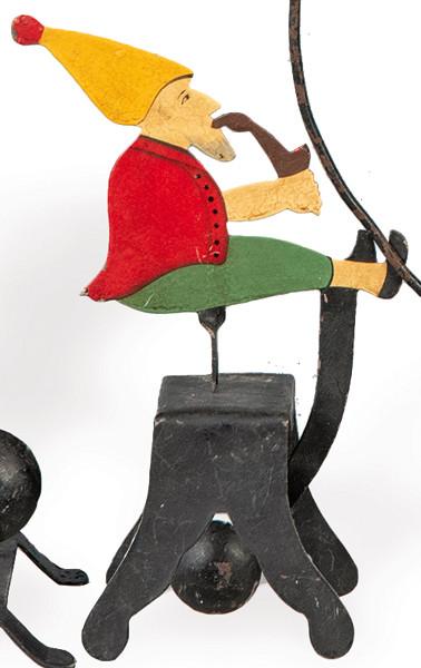 Tentetieso de hierro pintado en forma de gnomo fumando en pipa.