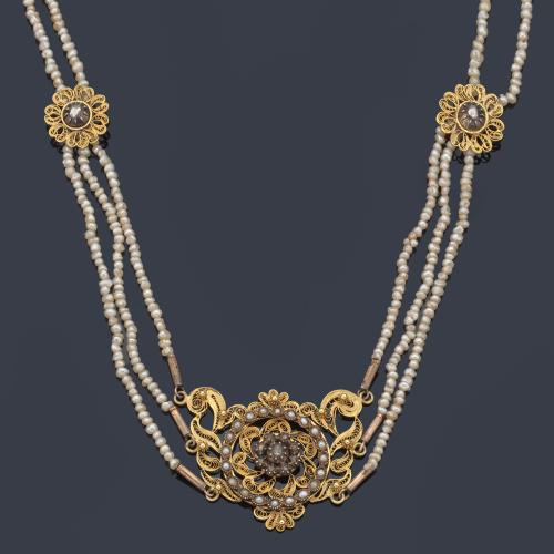 Collar 'mallorquín' con centro de filigrana realizado en oro amarillo de 18K, con orla de perlitas aljófar y centro de rosetón con diamantes talla rosa embutidos en tabla. S. XIX.