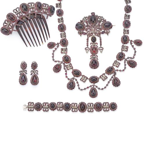 Completo parure época Victoriana compuesto por collar, pulsera, broche, pendientes y peineta con granates talla cabujón y facetados, con perlitas aljófar. Circa 1850-1870.