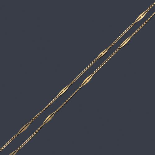 Cadena larga con motivos alargados en montura de oro amarillo de 18K.