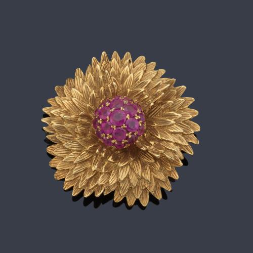Broche con diseño floral con centro de rubíes talla redonda, sobre montura en oro amarillo de 18K con gran profusión de detalles.