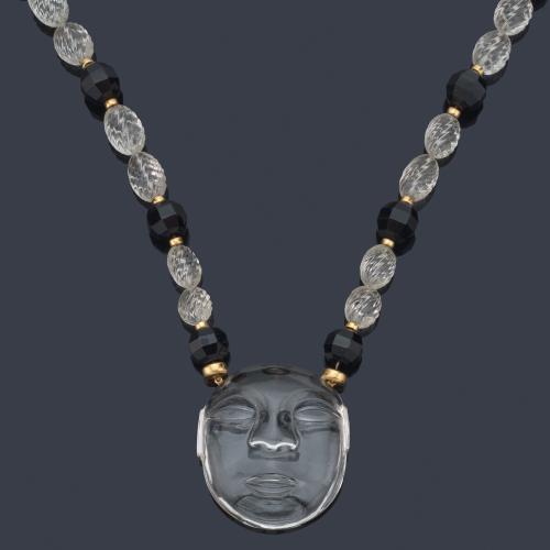 Collar largo con cuentas facetadas de ónix intercalado con cuentas de cristal de roca gallonadas, con remate de cara femenina tallado en cristal de roca.