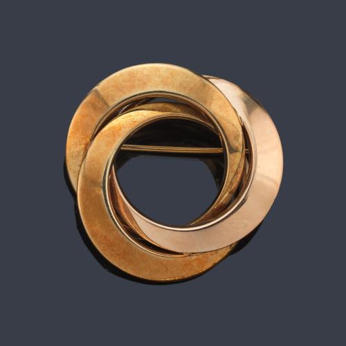 Broche con dos circulos entrelazados en montura de oro amarillo de 18K.