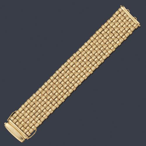 Pulsera ancha con motivo trenzado realizado en montura de oro amarillo de 18K.