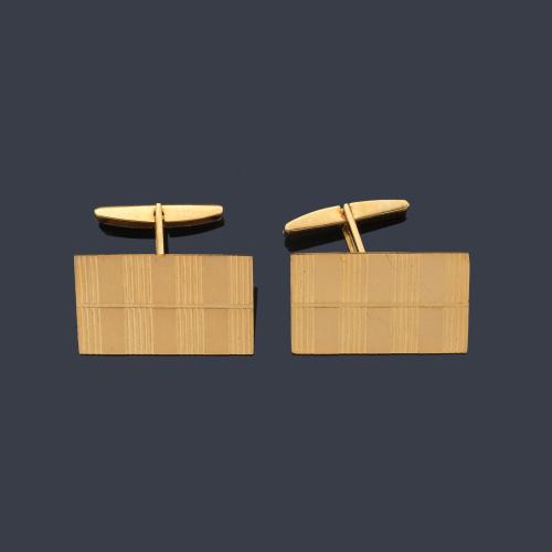 Gemelos rectangulares con decoración rallada en montura de oro amarillo de 18K.