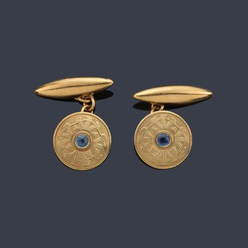 Gemelos con diseño circular y zafiro central talla redonda en montura de oro amarillo de 18K.