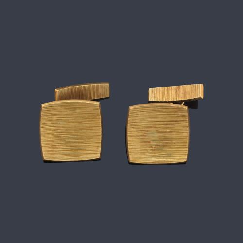 Gemelos con diseño cóncavo y decoración rallada en montura de oro amarillo mate de 18K.