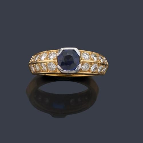 Anillo con zafiro talla redonda de aprox. 1,00 ct y doble banda de brillantes de aprox. 0,80 ct en ambos lados.
