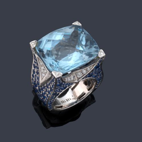  Anillo con aguamarina central facetada de aprox. 18,00 ct sobre montura cuajada de zafiros talla redonda y brillantes de aprox. 0,50 ct en total.