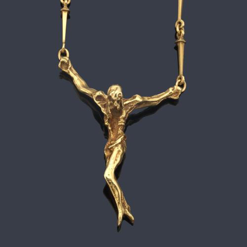 Collar con figura escultórica de cristo en montura de oro amarillo de 18K.