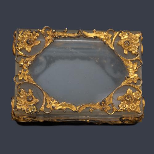 Caja decorativa realizada en cristal de roca enriquecida con motivos florales en plata dorada. S. XIX.