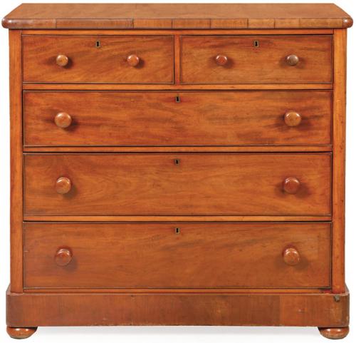 Cómoda Victoriana en madera de caoba, con dos cajones cortos sobre tres largos de altura decreciente y tiradores torneados.