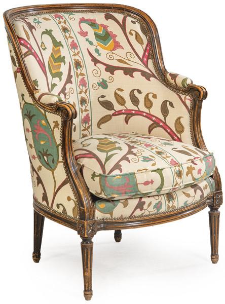 Butaca Luis XVI en madera de nogal tallada y moldurada, sobre patas estriadas. Tapicería de época posterior.