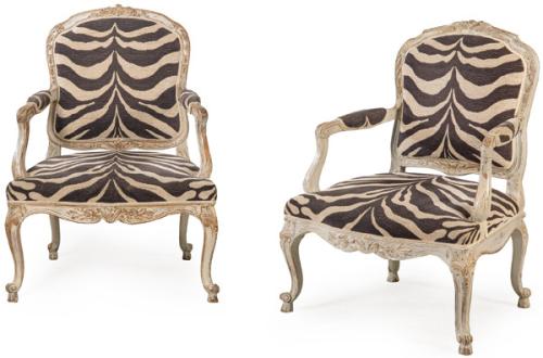 Pareja de butacas Luis XV, con respaldo a la reina en madera tallada con motivos vegetales y pintada de blanco, con desgastes. Tapicería de tela de época posterior simulando piel de cebra.Francia, segunda mitad S. XVIII