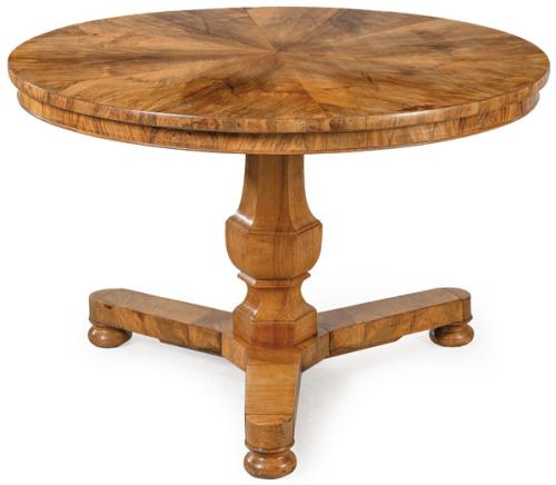 Mesa biedermeier, con tapa circular en madera de nogal, sobre pedestal abalaustrado sobre plataforma apoyada en patas en forma de bola torneadas.