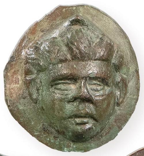  Aplique romano en bronce con un rostro masculino de cabello radiante, posiblemente la representación del Sol, SS I-II