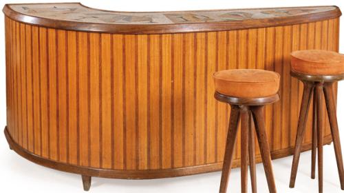 Barra de bar de H Muebles, estructura curva de madera de teca y palisandro, trasera con puertas correderas tipo persiana con lamas verticales.