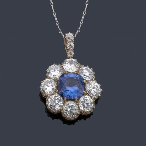 Colgante tipo rosetón con zafiro talla redonda central de aprox. 6,71 ct con orla de diamantes talla 'old cut european' de aprox. 8,44 ct en total. Finales S. XIX. Con estuche.