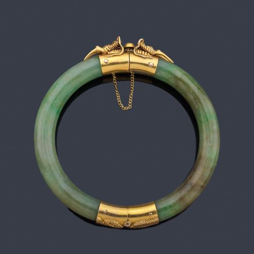 Pulsera rígida realizada en jade con dos motivos de cabeza de dragón en oro amarillo de 18K. Finales S. XIX.