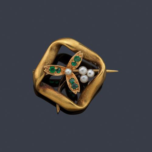 Broche con diseño floral con esmeraldas y perlitas en montura de oro amarillo de 18K.