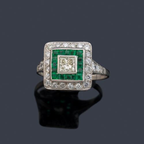 Anillo con diamante talla princesa y orla de brillantes de aprox. 1,10 ct en total con esmeraldas calibradas.