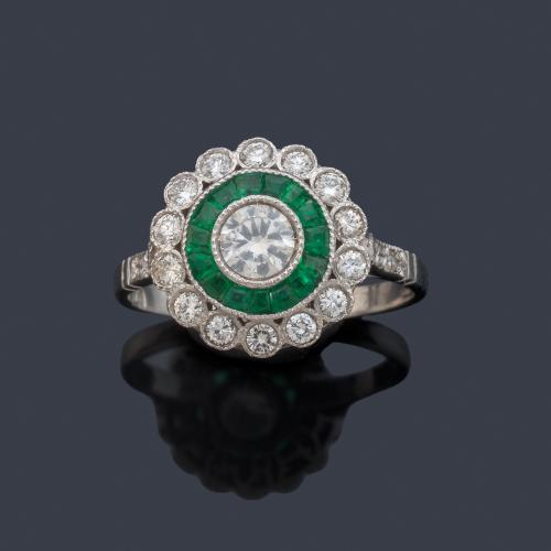 Anillo 'ojo de perdiz' con brillante central de aprox. 0,40 ct con orla de esmeraldas calibradas y diamantes.