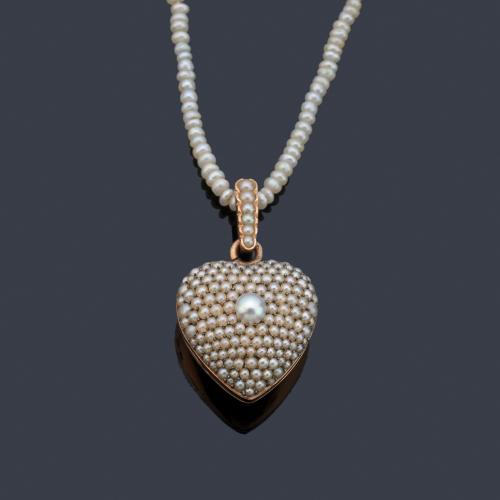 Colgante - guardapelo en forma de corazón con decoración de perlas aljófar en montura de oro rosa de 18K. Ppios S. XX.