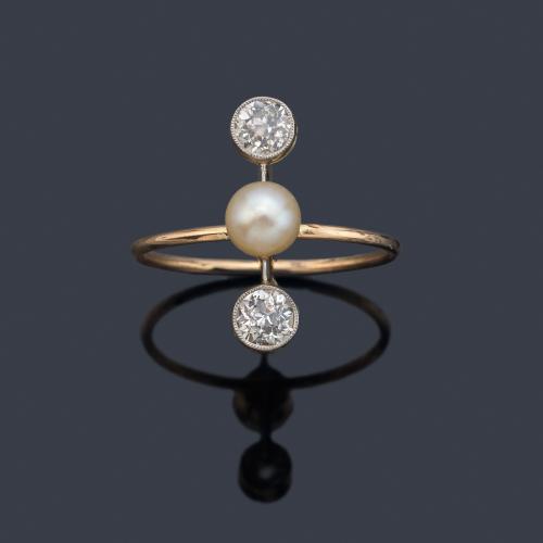 Anillo con perla central de aprox. 5,22 mm y dos diamantes talla antigua de aprox. 0,20 ct cada uno. Años '30.