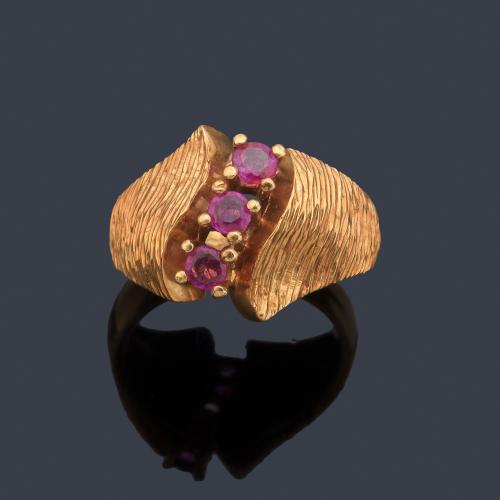 Anillo con banda de rubíes talla redonda en montura rallada de oro amarillo de 18K.