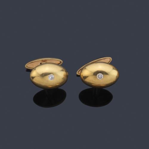 Gemelos con diseño ovalado con brillante central en montura de oro amarillo de 18K.