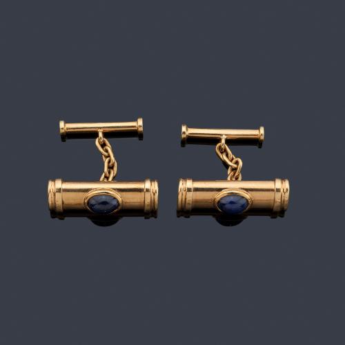 Gemelos con doble motivo de barrita con zafiro talla cabujón en montura de oro amarillo de 18K.