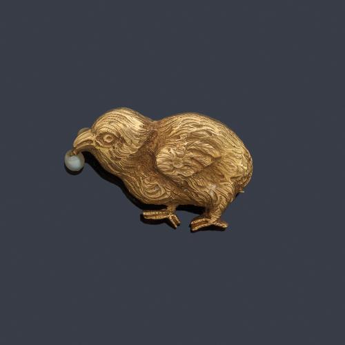 Broche con motivo de pollito con una perlita en el pico, realizado en oro amarillo de 18K.