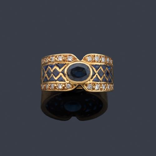 Anillo con zafiros talla oval y calibrados con banda de brillantes sobre montura de oro amarillo de 18K.