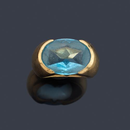Anillo con topacio azul facetado sobre montura de oro amarillo de 18K.
