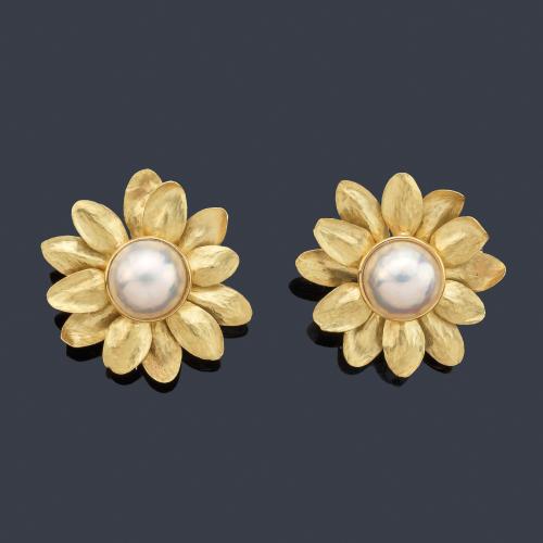 Pareja de broches con diseño floral, presenta perla japonesa central y pétalos en oro amarillo de 18K mate 'martelè'.
