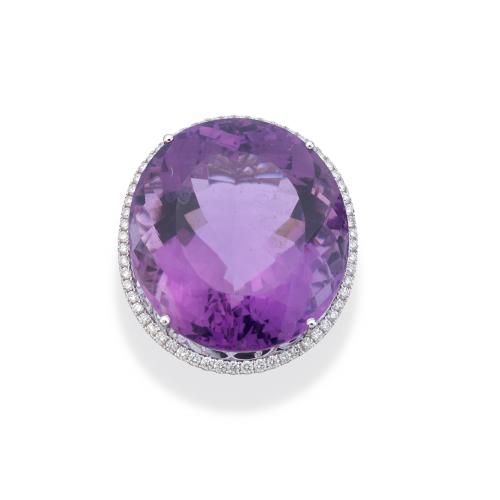  Anillo con gran amatista talla oval de aprox. 50,00 ct con orla de brillantitos de aprox. 0,58 ct en total.